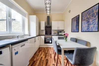 a kitchen with a table and chairs and a sink at Oaktree Appartment Moffat in Moffat