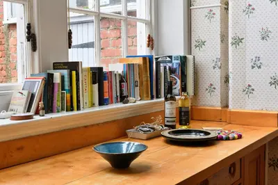 a wooden counter with books on a window sill at Finest Retreats - Edwardian Country House - 9 Bed, Sleeping up to 21 in Longtown