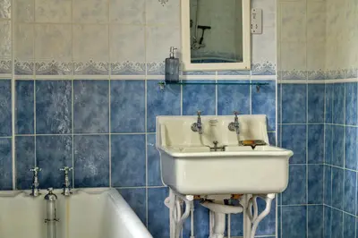 a bathroom with a sink and a bath tub at Finest Retreats - Edwardian Country House - 9 Bed, Sleeping up to 21 in Longtown