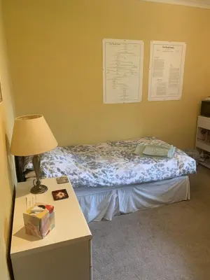 a bedroom with a bed and a table with a lamp at The Clan Boyd Room in Kilmarnock