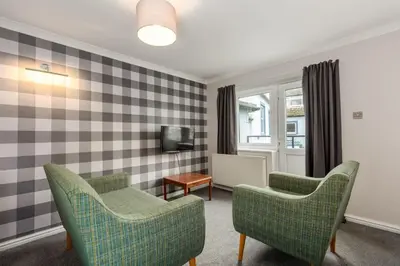 a living room with two chairs and a tv at Seacote Hotel in St Bees