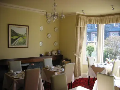 a dining room with tables and chairs and a window at Cragside Guest House in Keswick