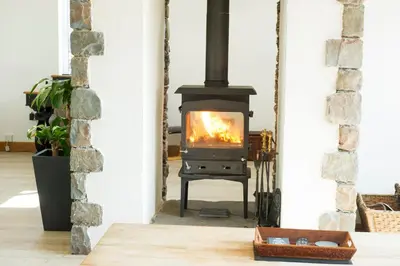 a stove in a living room with a fireplace at Graysonside in Cockermouth