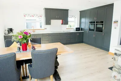 a kitchen with green cabinets and a wooden table at Graysonside in Cockermouth