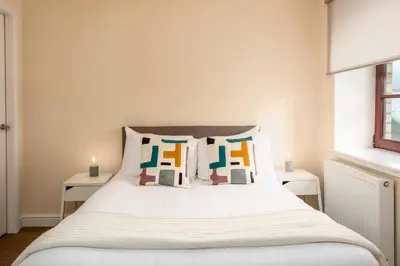 a bedroom with a bed with white sheets and pillows at Elliot Suite No7 - Donnini Apartments in Ayr