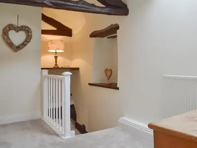 a hallway with white walls and wooden beams at Penfold in Dockray
