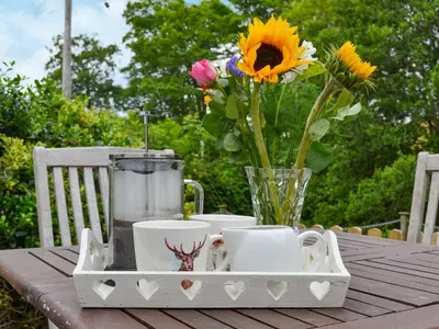 a tray with cups and a vase with flowers on a table at Penfold in Dockray