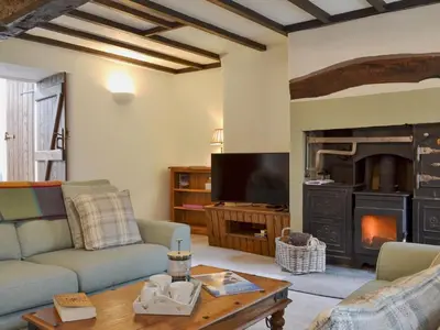 a living room with a couch and a fireplace at Penfold in Dockray