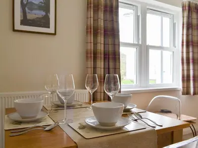 a dining room table with wine glasses and plates at 6 Elm Court in Keswick