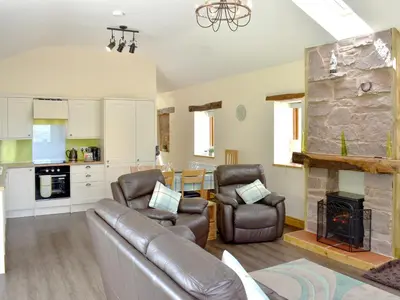 a living room with a couch and a fireplace at Wyndham Cottage in Dean