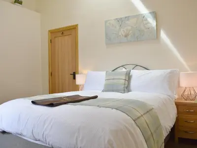 a bedroom with a large white bed with white pillows at Wyndham Cottage in Dean