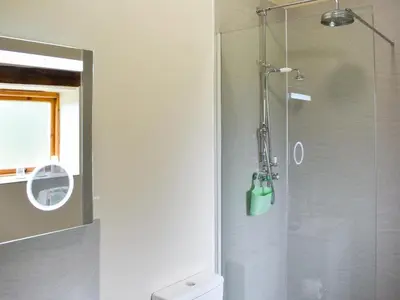 a shower with a glass door in a bathroom at Wyndham Cottage in Dean