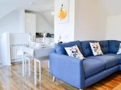 a blue couch and a table in a living room at 3 Old Posting Stables in Gatehouse of Fleet