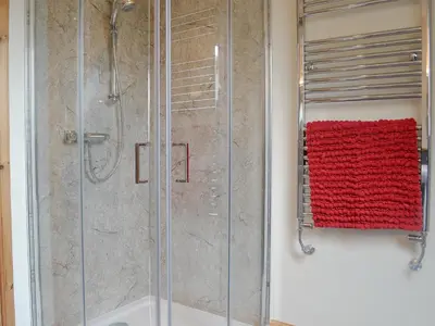 a bathroom with a shower with a red towel at The Soup Kitchen in Borgue