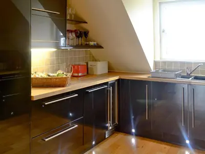 a kitchen with black cabinets and a basket of fruit at The Soup Kitchen in Borgue