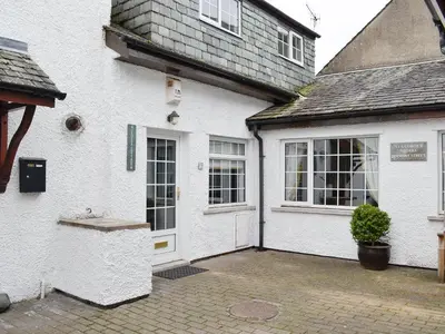 a white house with a white door and windows at Clover Cottage in Keswick