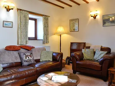 a living room with a leather couch and chairs at Owls Retreat in Whitehaven