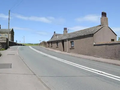 an empty road next to a brick building at Owls Retreat in Whitehaven