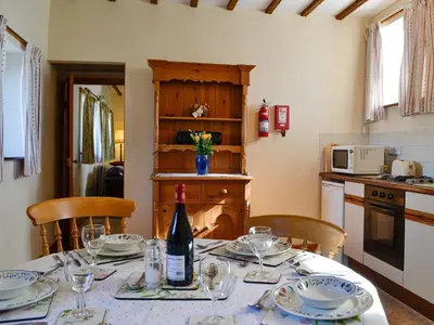 a kitchen with a table with a bottle of wine at Owls Retreat in Whitehaven