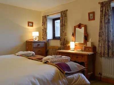 a bedroom with a bed and a desk and a mirror at Owls Retreat in Whitehaven
