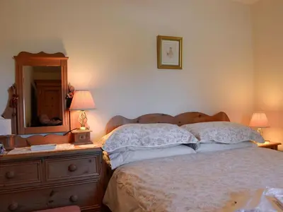 a bedroom with a bed and a dresser with a mirror at Owls Retreat in Whitehaven