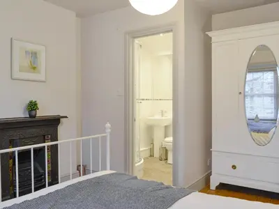 a bedroom with a bed and a sink and a mirror at Riverholme in Bassenthwaite