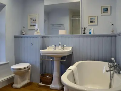 a bathroom with a sink and a tub and a toilet at Riverholme in Bassenthwaite