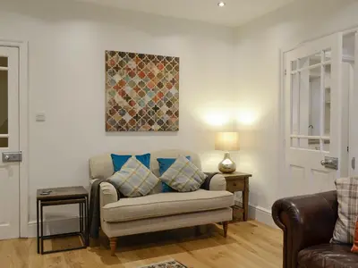 a living room with a couch and a painting on the wall at Riverholme in Bassenthwaite