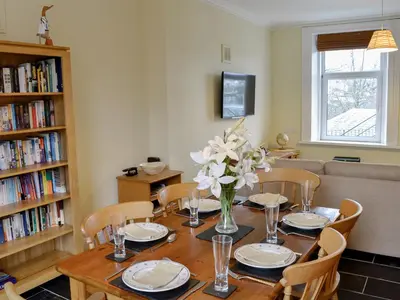 a dining room table with a vase of flowers on it at Lake Road Heights in Keswick