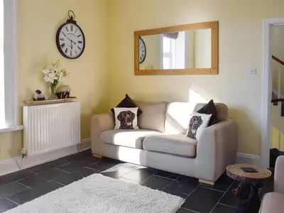 a living room with a couch and a mirror at Lake Road Heights in Keswick