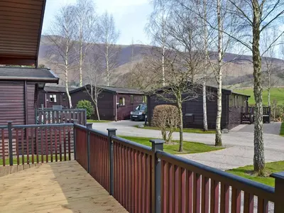 a wooden fence in front of a house with a driveway at Bransty in Keswick