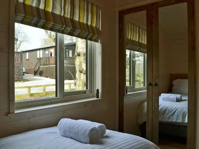 a bedroom with a bed and a large window at Bransty in Keswick