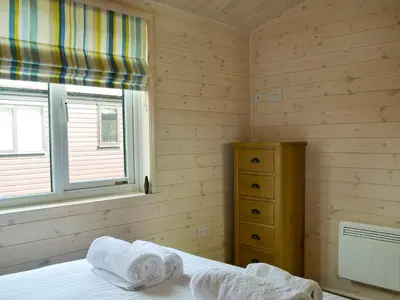 a bedroom with a bed and a window and a dresser at Bransty in Keswick