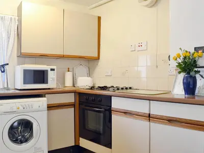 a kitchen with a washing machine and a microwave at Swallows Return in Whitehaven