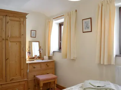 a bedroom with a wooden dresser and a window at Swallows Return in Whitehaven
