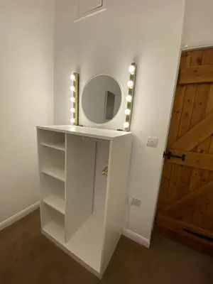 a white cabinet with a mirror and lights on it at The Bothey in Brampton