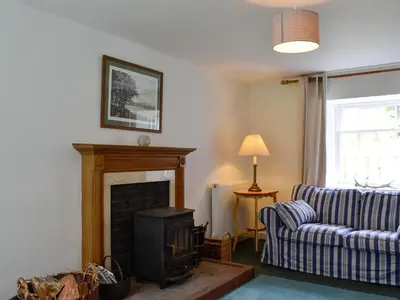 a living room with a fireplace and a couch at Shore Cottage - Uk12524 in Garlieston