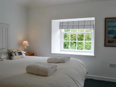 a bedroom with two beds and a window at Shore Cottage - Uk12524 in Garlieston