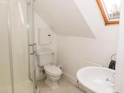 a white bathroom with a toilet and a sink at Ivy Bank in Thornhill