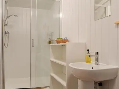 a white bathroom with a sink and a shower at Robin's Lodge in Westward