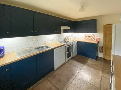 a kitchen with dark blue cabinets and a sink at High Birch Close in Patterdale