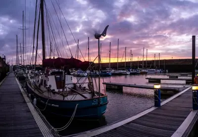 a boat is docked in a marina at sunset at Maryport House in Maryport