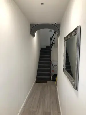a hallway with a staircase with a mirror and a mirror at Maryport House in Maryport