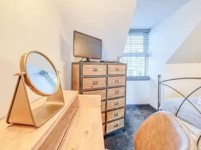 a bedroom with a mirror and a dresser at Saltlife Cottage in Port William