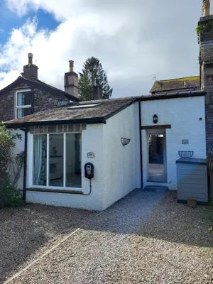 a white house with a window and a door at Juniper HAYLOFT Grasmere in Ambleside