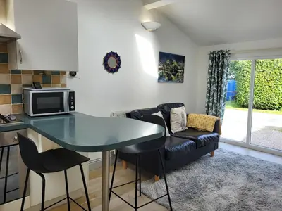 a kitchen and living room with a table and a microwave at Juniper HAYLOFT Grasmere in Ambleside