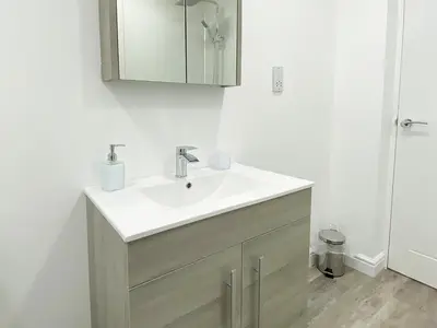 a bathroom with a white sink and a mirror at Ritson Wharf in Maryport