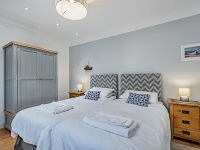 a bedroom with two beds with white sheets and blue pillows at Killantrae Burn in Port William