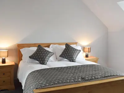 a bedroom with a bed with two pillows on it at The School House in New Luce