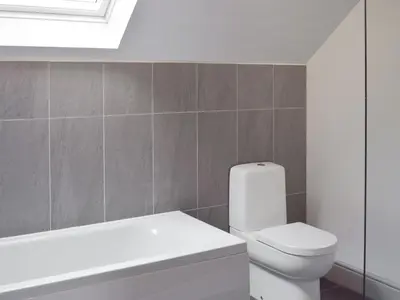 a bathroom with a white toilet and a bath tub at The School House in New Luce